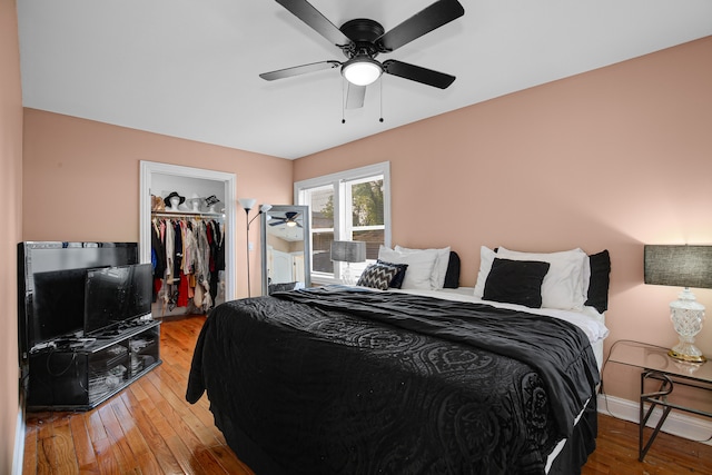 bedroom featuring ceiling fan, a closet, wood-type flooring, and a spacious closet