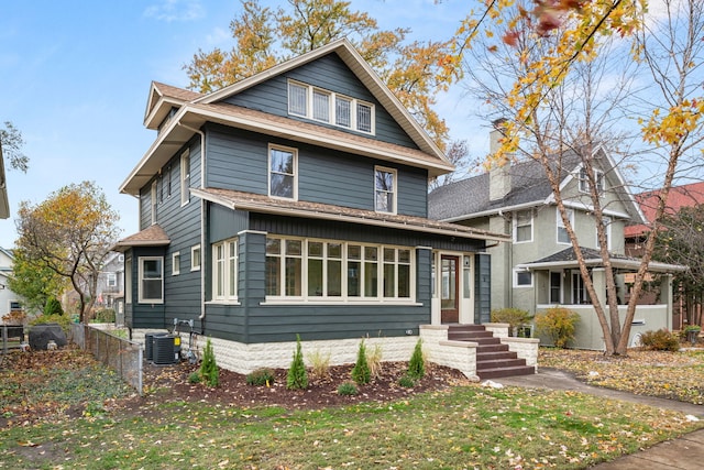 front facade featuring a front yard and central air condition unit