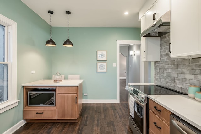 kitchen with white cabinetry, hanging light fixtures, light stone countertops, backsplash, and appliances with stainless steel finishes