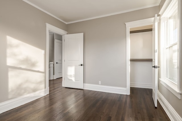 unfurnished bedroom featuring dark wood-type flooring, crown molding, and a closet