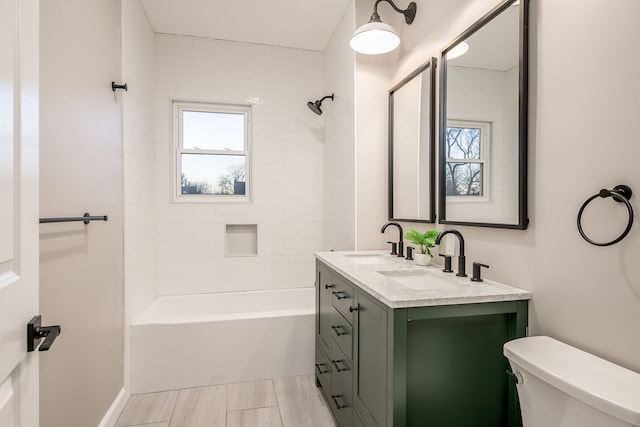 full bathroom featuring toilet, vanity, tiled shower / bath combo, and a wealth of natural light