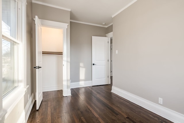 unfurnished bedroom featuring crown molding, dark hardwood / wood-style floors, and a closet