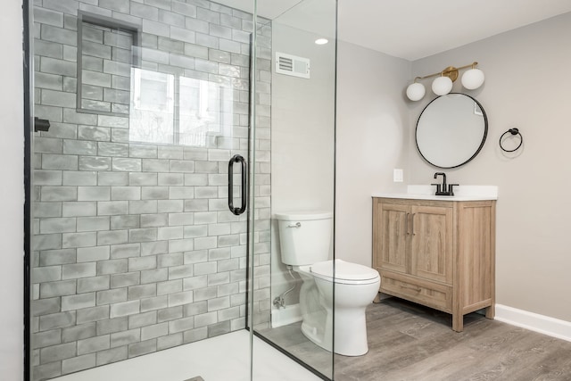 bathroom featuring toilet, hardwood / wood-style flooring, an enclosed shower, and vanity