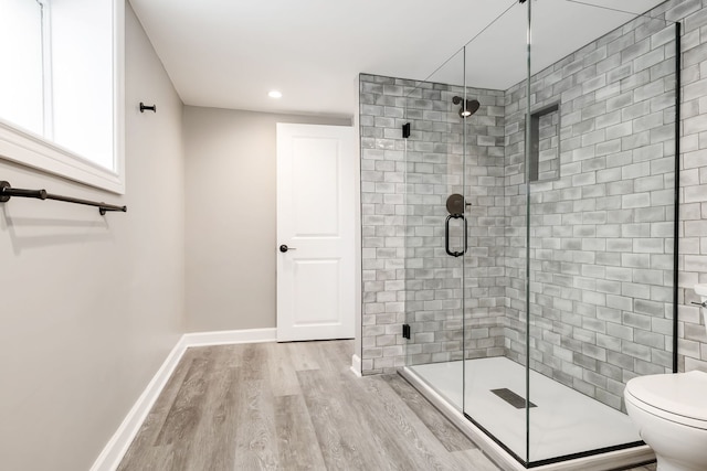 bathroom featuring hardwood / wood-style floors, an enclosed shower, and toilet