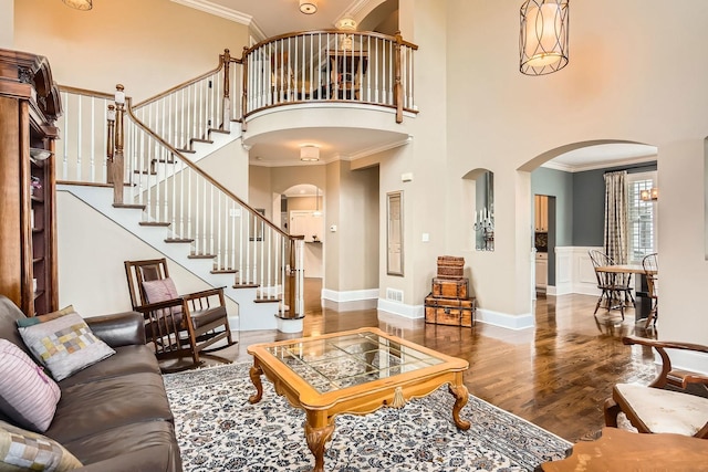 living room featuring dark hardwood / wood-style floors, ornamental molding, and a high ceiling