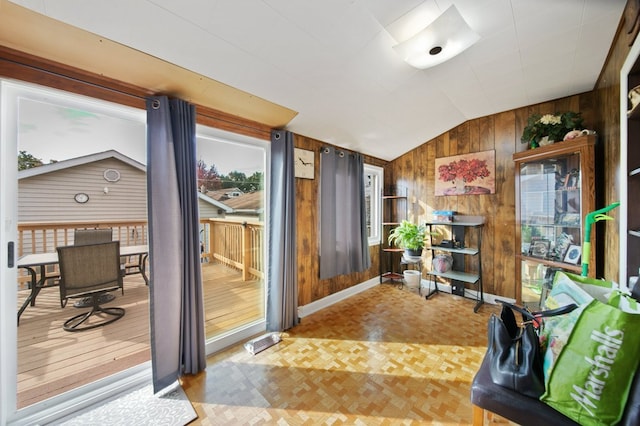 interior space with light parquet flooring, lofted ceiling, and wood walls