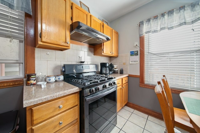 kitchen with decorative backsplash, light tile patterned floors, stainless steel gas range, and ventilation hood