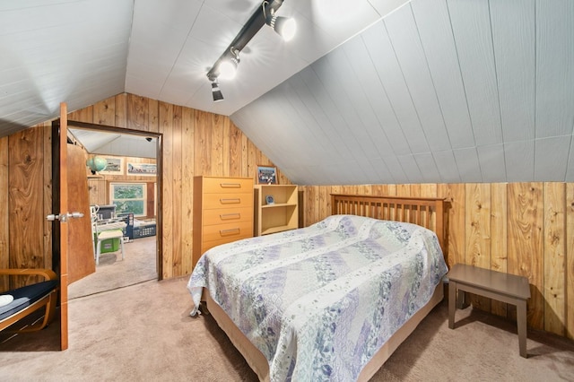 carpeted bedroom with lofted ceiling, wooden walls, and track lighting