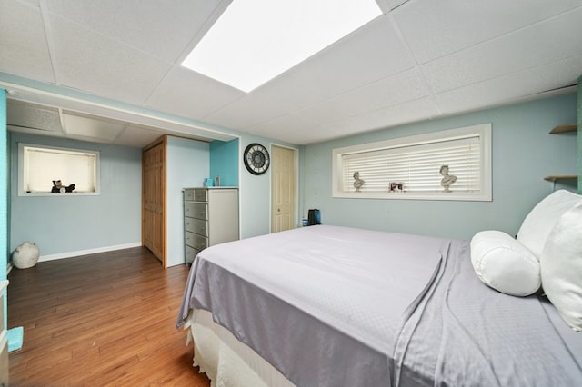 bedroom with hardwood / wood-style floors and a drop ceiling