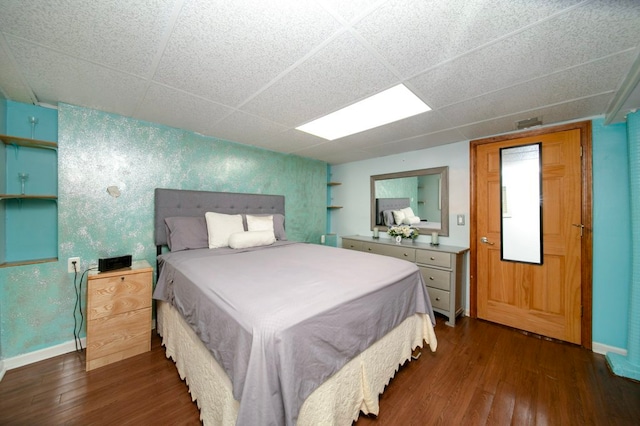 bedroom featuring dark hardwood / wood-style flooring and a paneled ceiling