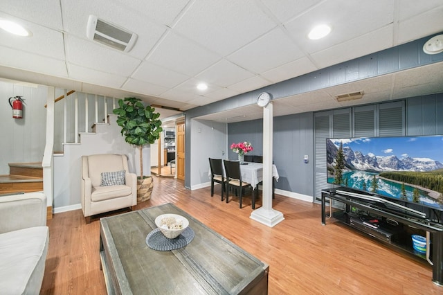 living room featuring a drop ceiling and hardwood / wood-style flooring