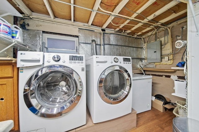 washroom with electric panel, washer and clothes dryer, and dark wood-type flooring