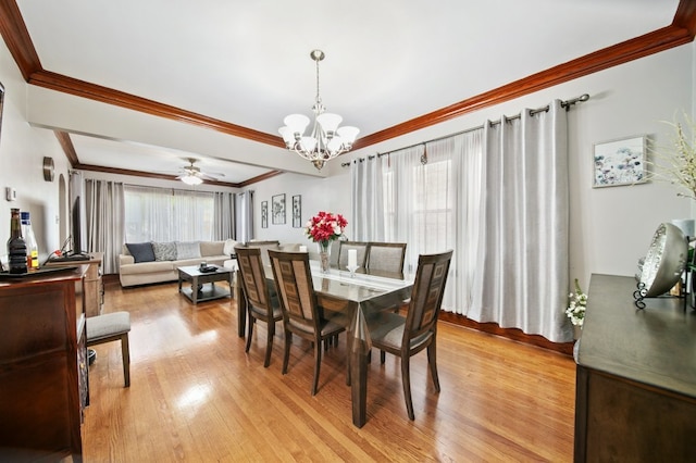 dining area with ceiling fan with notable chandelier, light wood-type flooring, and crown molding