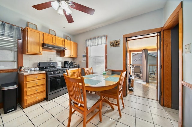 kitchen featuring decorative backsplash, black gas stove, light tile patterned floors, and ceiling fan