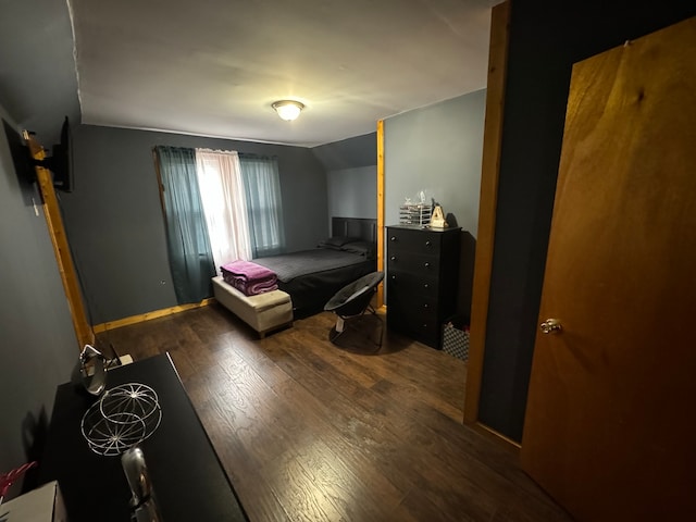 bedroom featuring dark wood-type flooring and vaulted ceiling