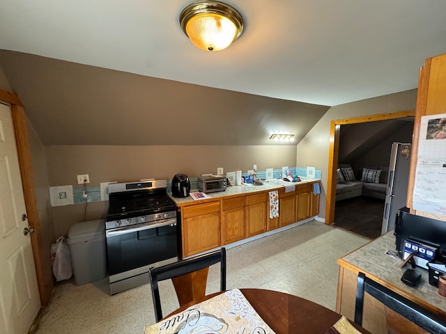 interior space featuring stainless steel gas stove and vaulted ceiling