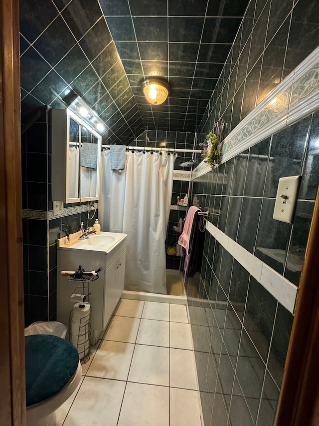 bathroom with a shower with curtain, vanity, tile walls, tile patterned flooring, and toilet