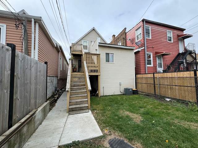 rear view of house with a lawn and central AC