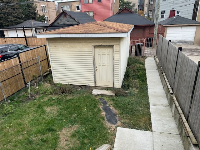 view of outdoor structure featuring a yard and central AC