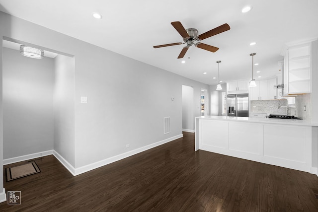 kitchen featuring kitchen peninsula, pendant lighting, stainless steel fridge with ice dispenser, dark hardwood / wood-style floors, and white cabinetry