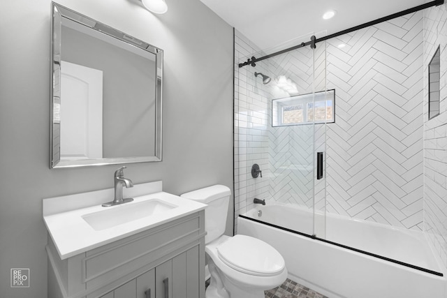 full bathroom with vanity, bath / shower combo with glass door, and toilet