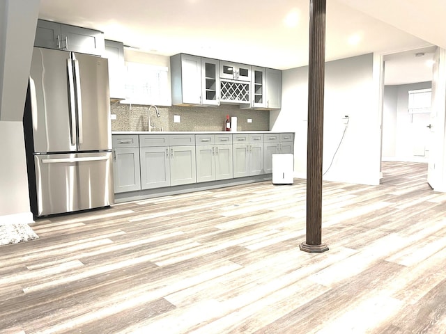 kitchen featuring stainless steel fridge, tasteful backsplash, and light hardwood / wood-style floors