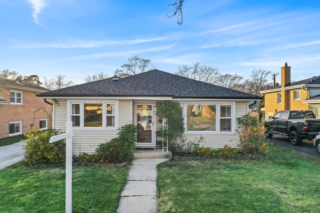 bungalow-style home featuring a front lawn