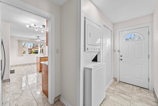 washroom with stacked washer and dryer and ceiling fan