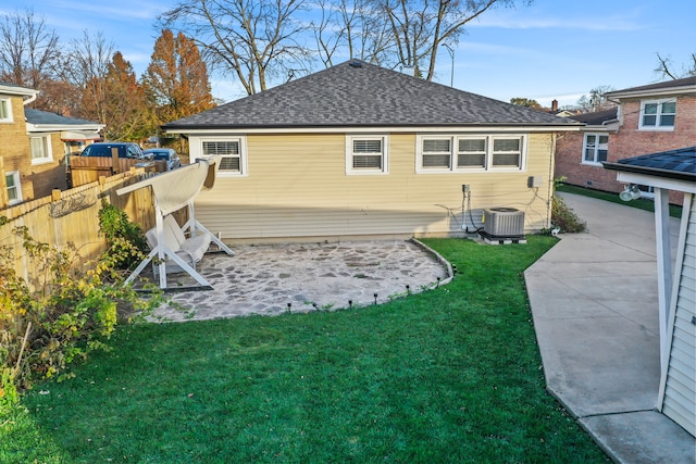 back of property featuring a lawn, central air condition unit, and a patio