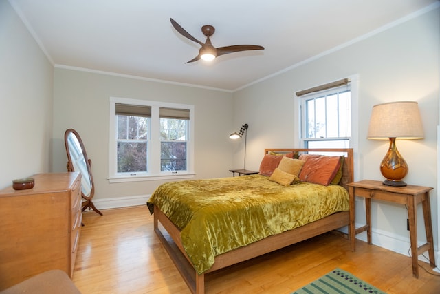 bedroom featuring light hardwood / wood-style flooring, multiple windows, ornamental molding, and ceiling fan