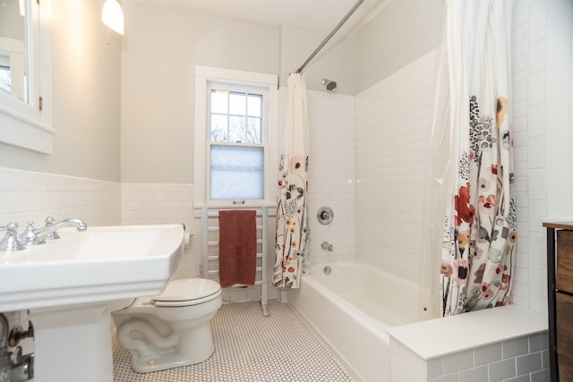 bathroom featuring tile patterned flooring, toilet, tile walls, and shower / tub combo