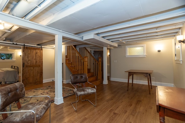 basement featuring a barn door and wood-type flooring