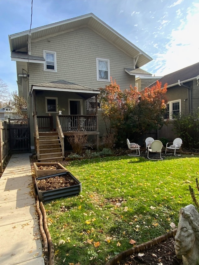 rear view of house featuring a lawn and a wooden deck