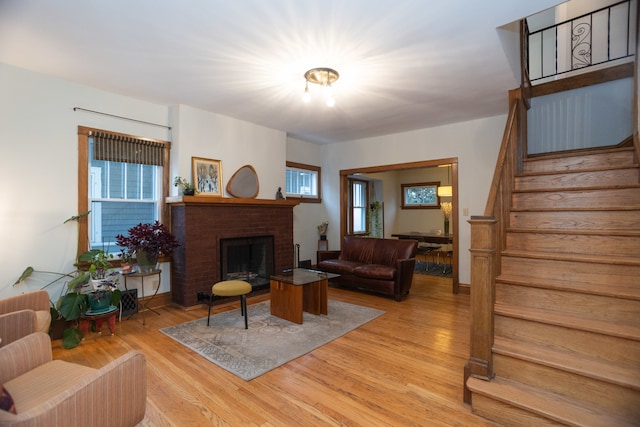 living room featuring light hardwood / wood-style floors and a brick fireplace