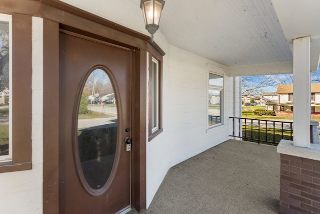 view of exterior entry featuring covered porch