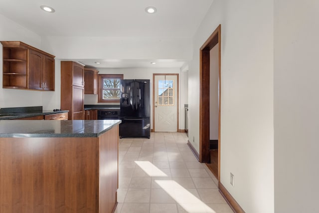 kitchen with black fridge with ice dispenser, kitchen peninsula, and light tile patterned floors