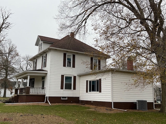 rear view of house featuring a lawn, a porch, and central AC