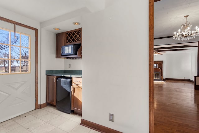 interior space with ceiling fan with notable chandelier, black appliances, decorative light fixtures, and light hardwood / wood-style floors