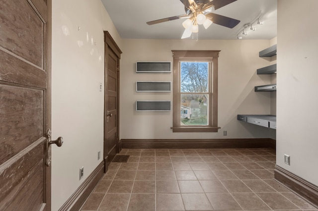 washroom with ceiling fan and dark tile patterned floors