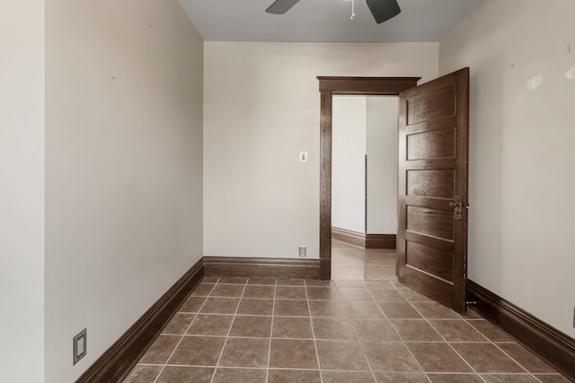 empty room featuring ceiling fan and dark tile patterned flooring