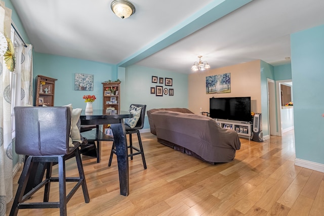 living room featuring an inviting chandelier and light hardwood / wood-style flooring