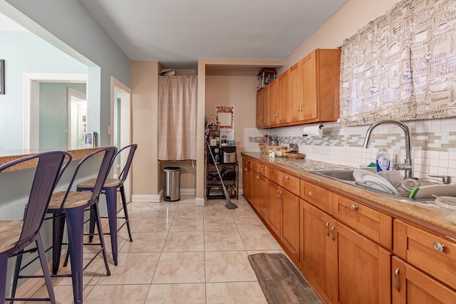 kitchen featuring light tile patterned flooring, backsplash, and sink