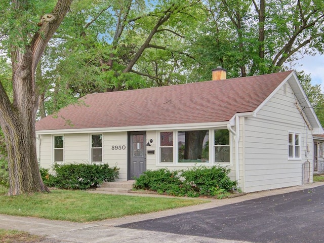 ranch-style home featuring a front lawn