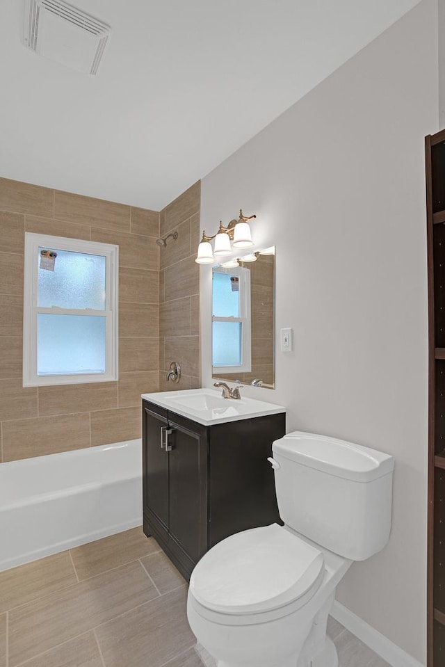 full bathroom featuring vanity, toilet, and tiled shower / bath