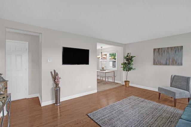 living room with dark hardwood / wood-style floors and a notable chandelier