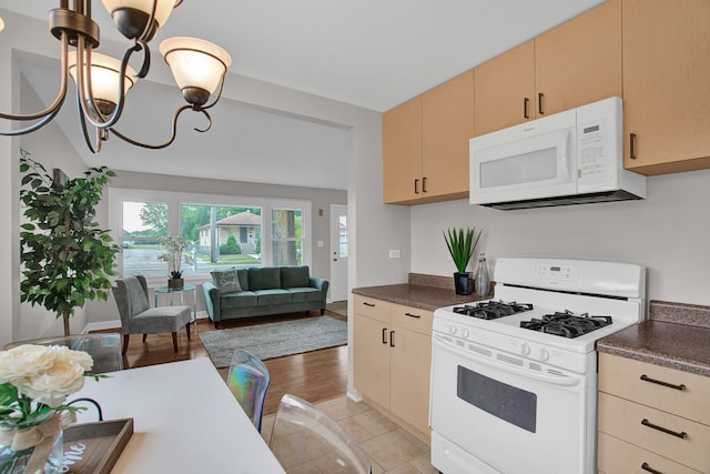 kitchen with light brown cabinets, white appliances, an inviting chandelier, and light tile patterned floors