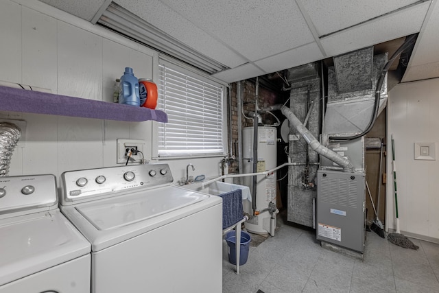 washroom featuring heating unit, water heater, sink, and washer and dryer