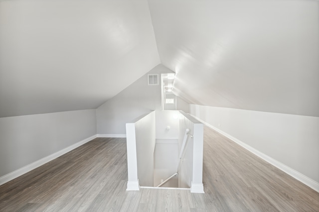 additional living space with lofted ceiling and light hardwood / wood-style flooring