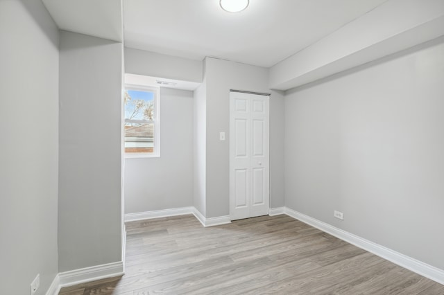 unfurnished bedroom with a closet and light hardwood / wood-style flooring