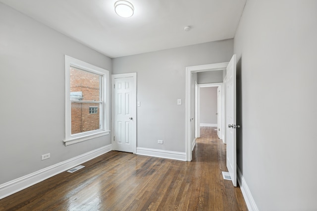 unfurnished bedroom with a closet and dark hardwood / wood-style flooring